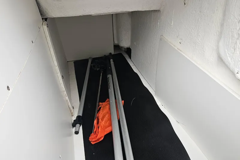 Slide: The Image of Storage compartment in a 2017 Sea Ray SDX 240 Outboard boat with poles and orange fabric. - 23