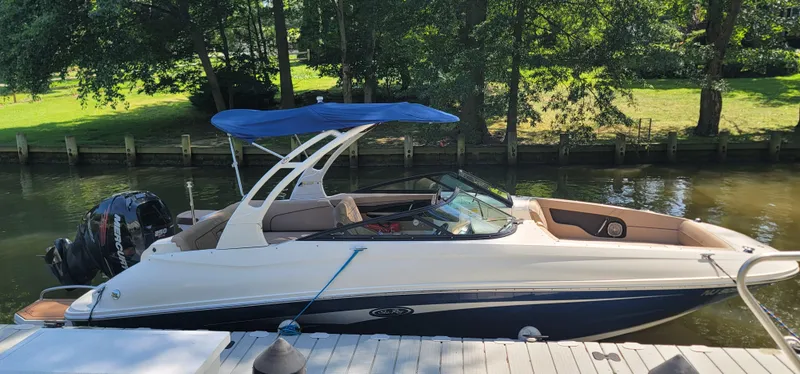 Slide: The Image of 2017 Sea Ray SDX 240 Outboard boat docked by a serene riverside. - 3