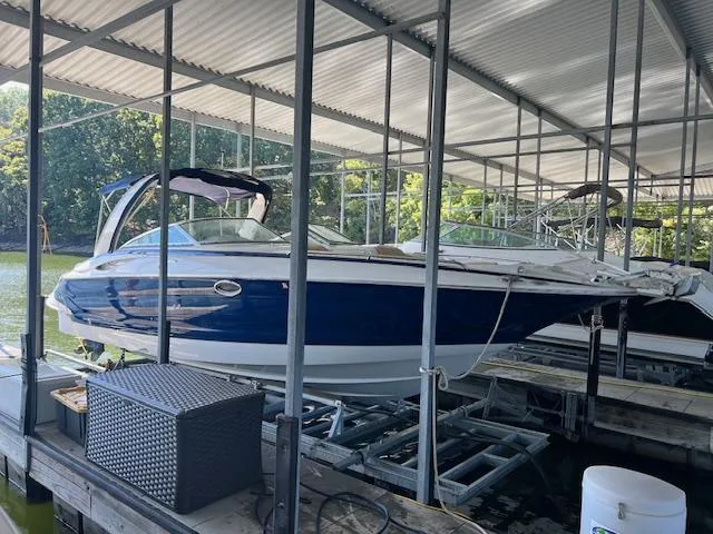 The Image of 2012 Crownline 325 SS boat docked under a covered marina. - 0
