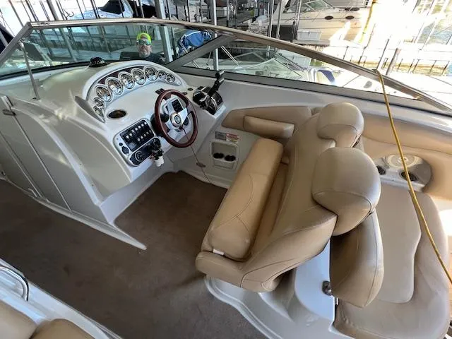 Slide: The Image of 2012 Crownline 325 SS boat interior with beige seating and modern dashboard controls. - 12