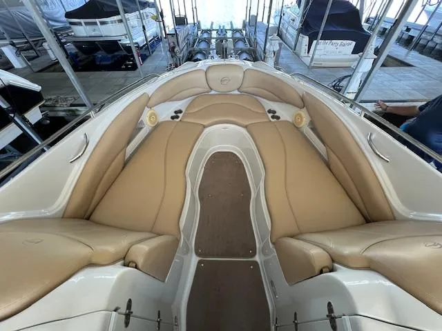 Slide: The Image of 2012 Crownline 325 SS boat interior with tan leather seating in a marina. - 24