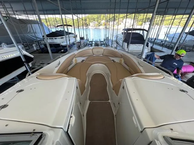 Slide: The Image of 2012 Crownline 325 SS boat interior with tan seating, docked in a marina. - 25