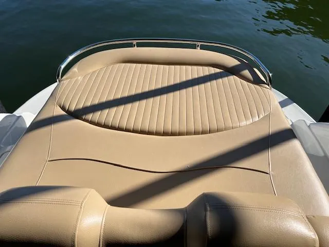 Slide: The Image of 2012 Crownline 325 SS boat with beige leather seating, docked on calm water. - 30