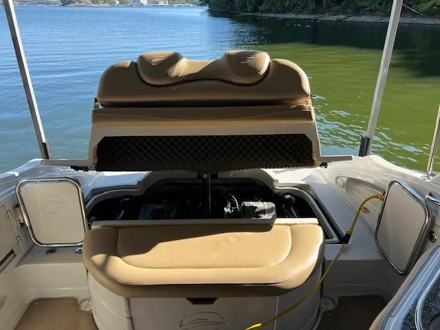 Slide: The Image of 2012 Crownline 325 SS boat with open engine compartment, docked by a scenic lake. - 32