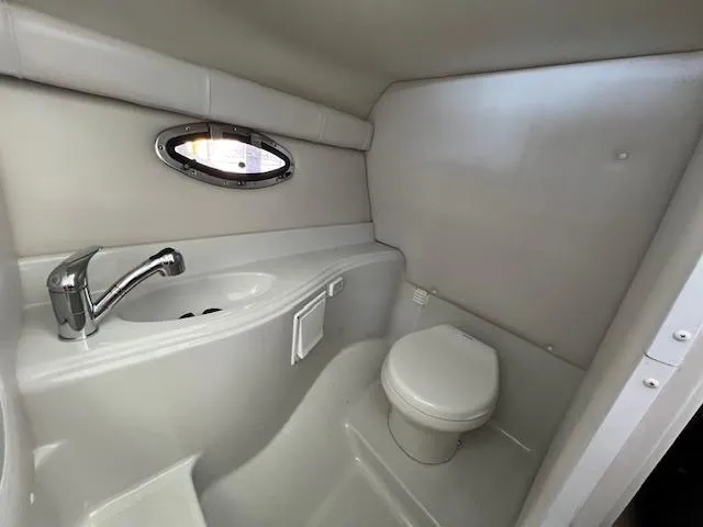 Slide: The Image of 2012 Crownline 325 SS boat bathroom with sink and toilet. - 36