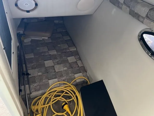 Slide: The Image of Interior cabin of 2012 Crownline 325 SS boat with patterned bedding and coiled yellow cable. - 40