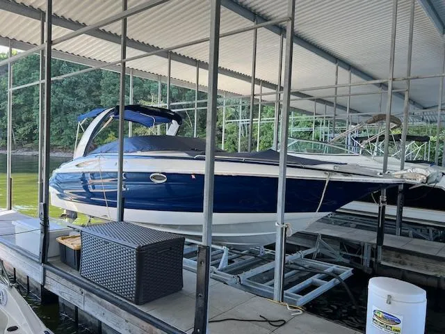Slide: The Image of 2012 Crownline 325 SS boat docked under a covered marina. - 5