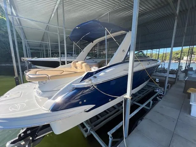 Slide: The Image of 2012 Crownline 325 SS boat docked under a metal canopy. - 6