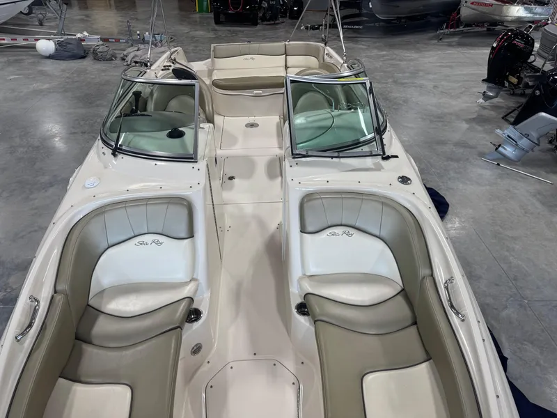 Slide: The Image of 2005 Sea Ray 240 Sundeck boat with spacious seating in a showroom. - 10
