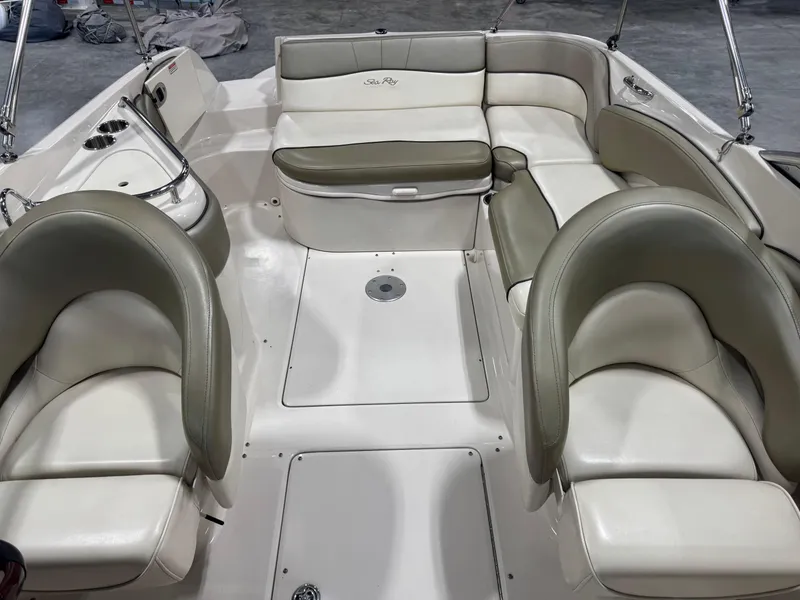 Slide: The Image of 2005 Sea Ray 240 Sundeck interior with white and beige seating arrangement. - 11
