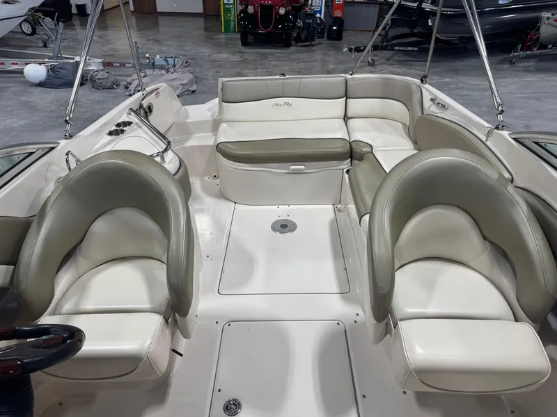 Slide: The Image of 2005 Sea Ray 240 Sundeck interior with white and gray seating in a showroom. - 12