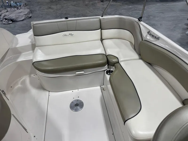 Slide: The Image of 2005 Sea Ray 240 Sundeck interior seating with white and beige upholstery. - 9
