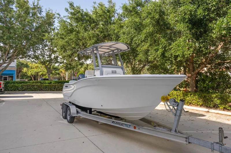 Slide: The Image of 2025 Sea Fox 228 Commander boat on trailer, parked outdoors with trees in background. - 6