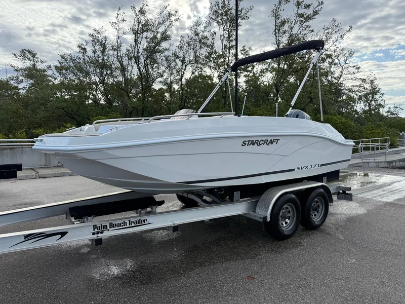 Slide: The Image of 2024 Starcraft SVX 171 OB boat on trailer, parked outdoors under cloudy sky. - 3