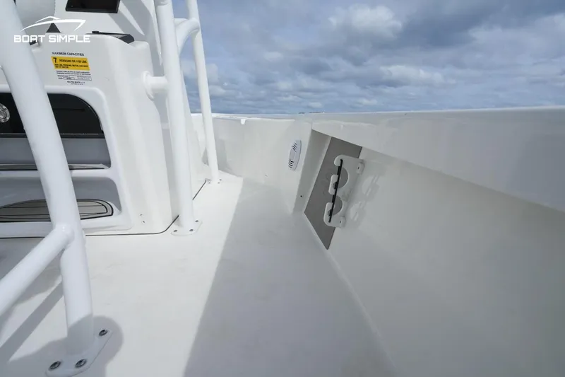 Slide: The Image of 2023 Sea Pro 208 Bay boat interior with white deck and railing under cloudy sky. - 9