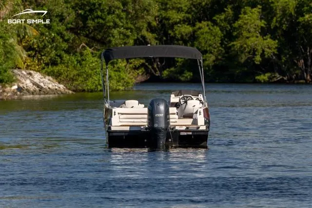 Slide: The Image of 2023 Starcraft SVX 231 OB DH boat on a serene lake with lush greenery. - 3