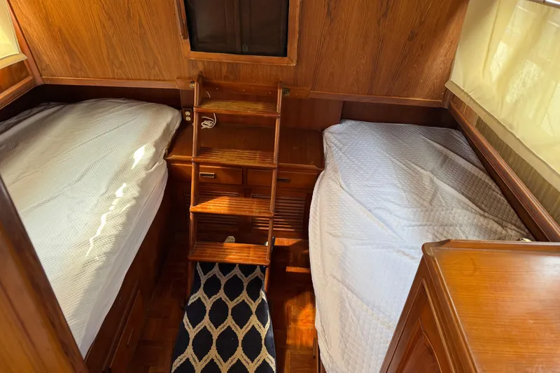 Slide: The Image of 1981 Marine Trader 34 Double Cabin interior with twin beds and wooden furnishings. - 10