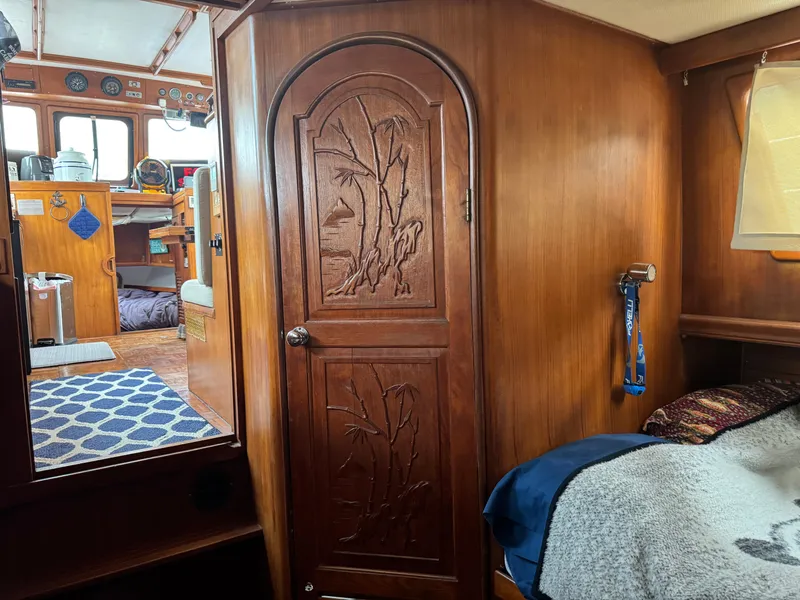 Slide: The Image of 1981 Marine Trader 34 Double Cabin interior with carved wooden door and cozy cabin space. - 11