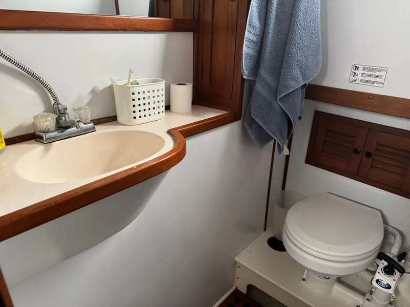 Slide: The Image of 1981 Marine Trader 34 Double Cabin bathroom with sink, toilet, and towel. - 13