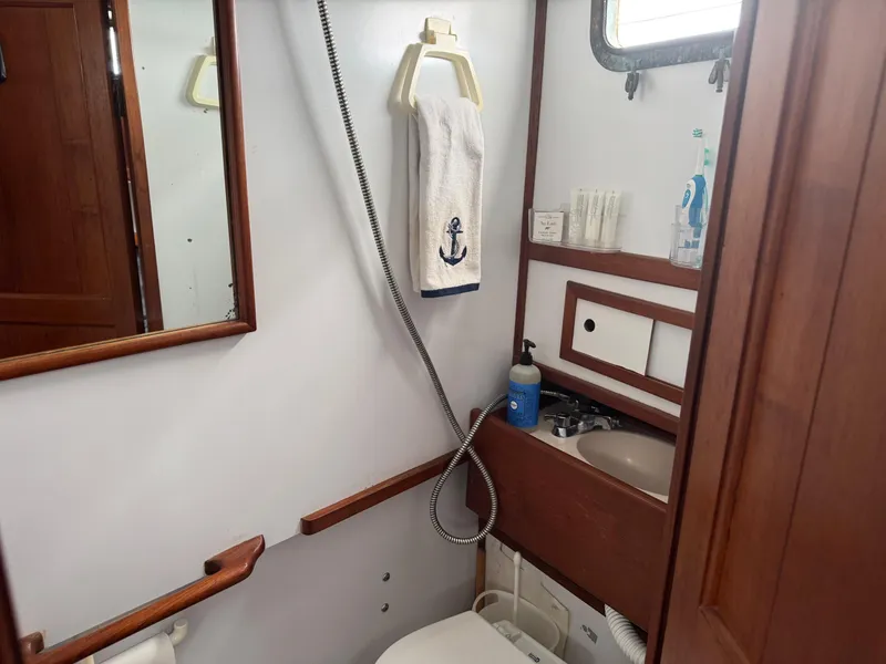 Slide: The Image of 1981 Marine Trader 34 Double Cabin bathroom with wooden accents and nautical-themed decor. - 15