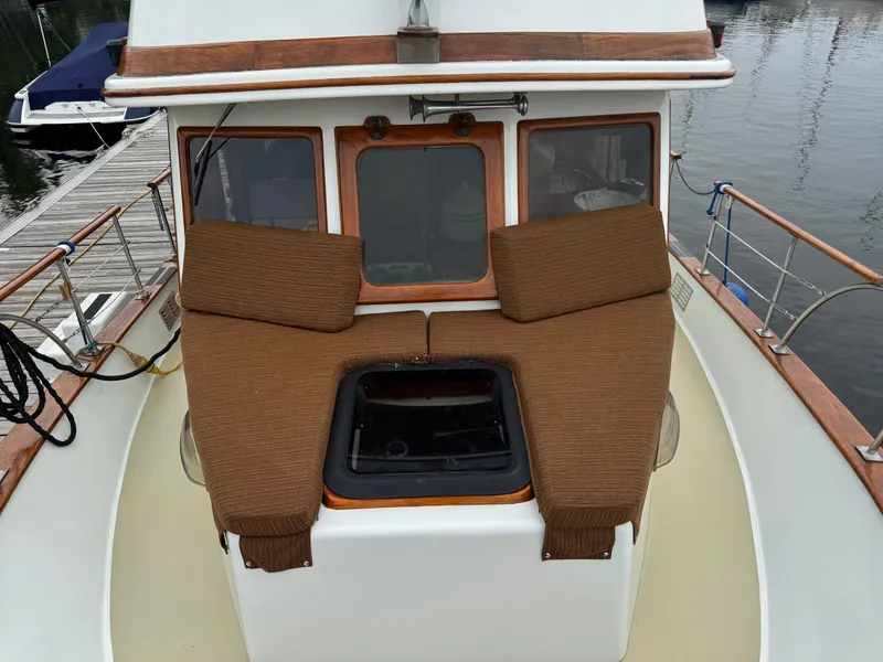 Slide: The Image of 1981 Marine Trader 34 Double Cabin boat with brown cushions on deck, docked at marina. - 17