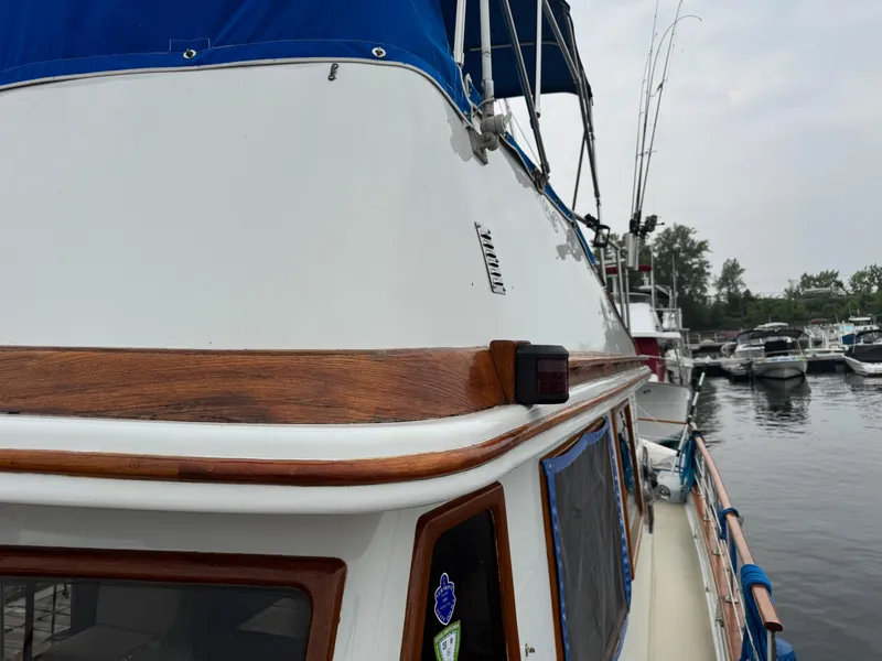 Slide: The Image of 1981 Marine Trader 34 Double Cabin boat docked at marina, featuring wooden trim and blue canopy. - 19