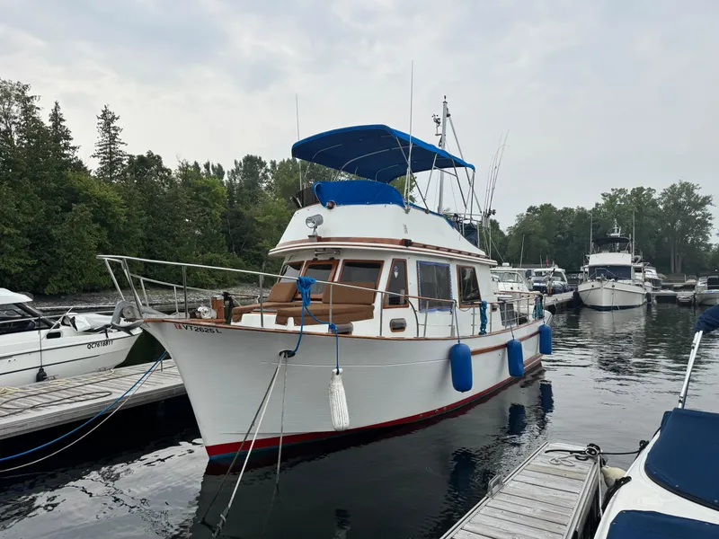 Slide: The Image of 1981 Marine Trader 34 Double Cabin docked at a marina, surrounded by other boats. - 2