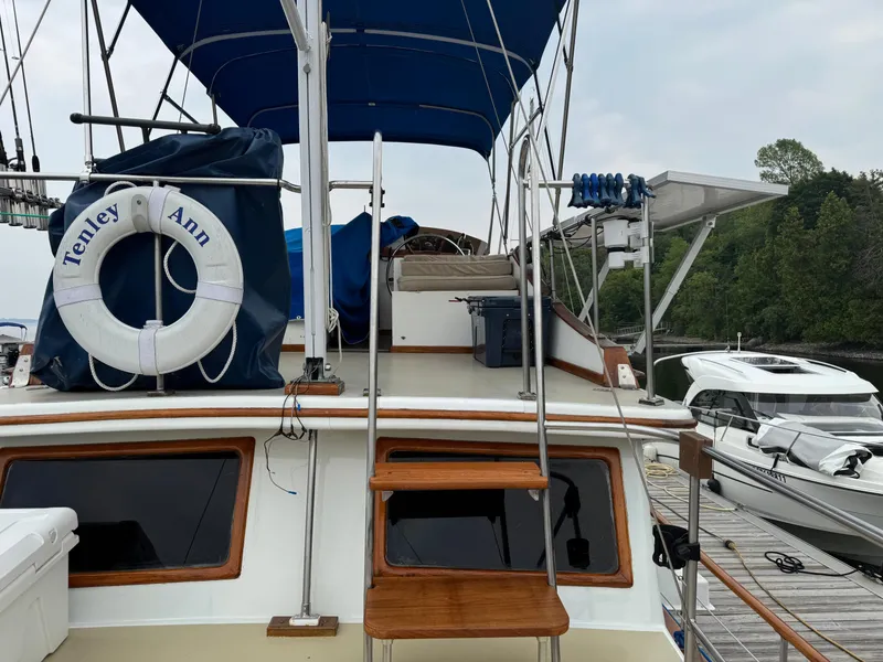 Slide: The Image of 1981 Marine Trader 34 Double Cabin boat docked, featuring a blue canopy and life preserver. - 21