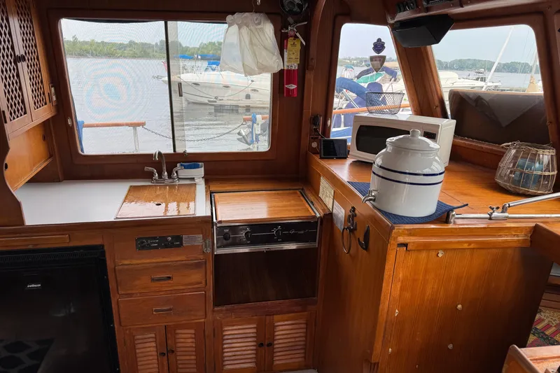 Slide: The Image of 1981 Marine Trader 34 Double Cabin interior with wooden cabinetry, sink, and microwave. - 3