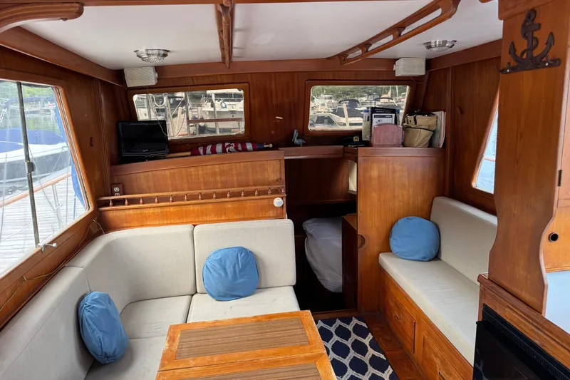 Slide: The Image of 1981 Marine Trader 34 Double Cabin interior with wood paneling and cozy seating area. - 4