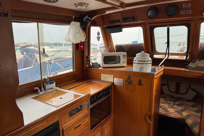 Slide: The Image of 1981 Marine Trader 34 Double Cabin interior with kitchenette, microwave, and nautical decor. - 6
