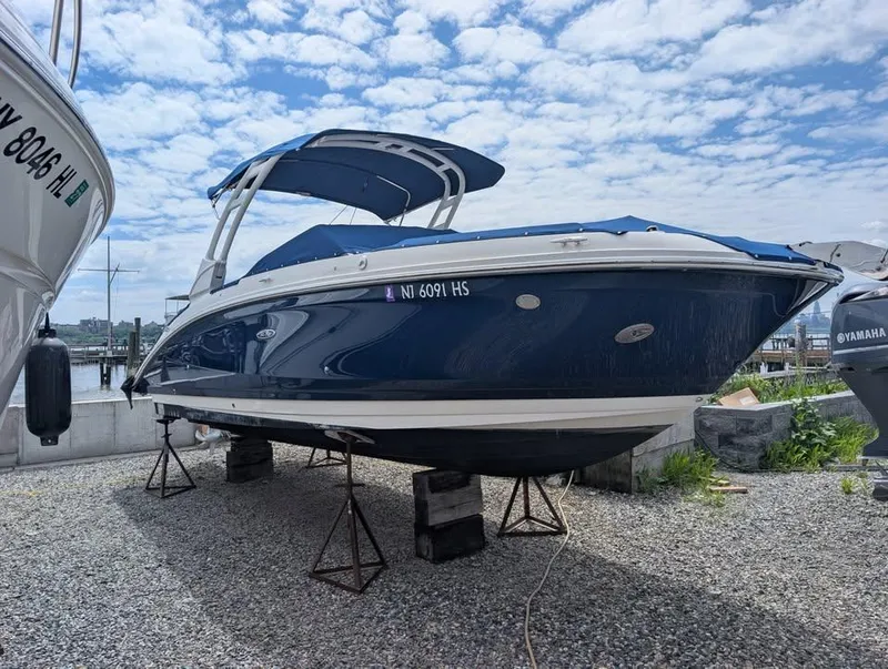 The Image of 2021 Sea Ray SDX 270 Outboard boat on stands, blue hull, marina background. - 0