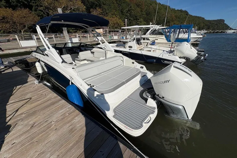 Slide: The Image of 2021 Sea Ray SDX 270 Outboard docked, featuring spacious seating and Mercury engine. - 12