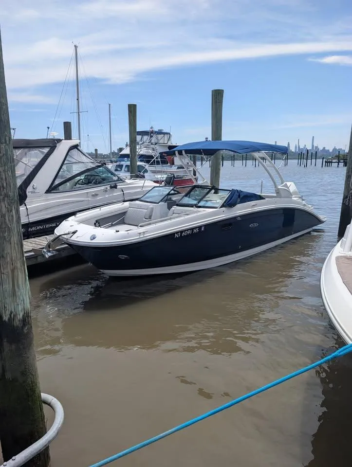 Slide: The Image of 2021 Sea Ray SDX 270 Outboard boat on dry dock with blue canopy. - 2