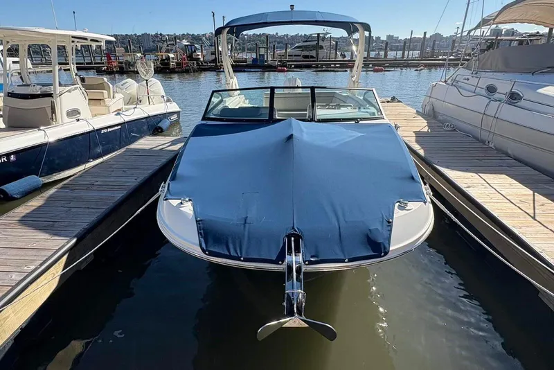 Slide: The Image of 2021 Sea Ray SDX 270 Outboard docked, covered with a blue tarp, in a marina. - 24
