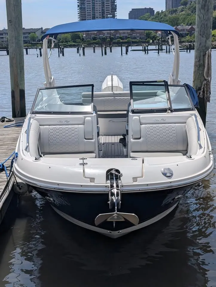 Slide: The Image of 2021 Sea Ray SDX 270 Outboard boat docked at a marina under a blue sky. - 3