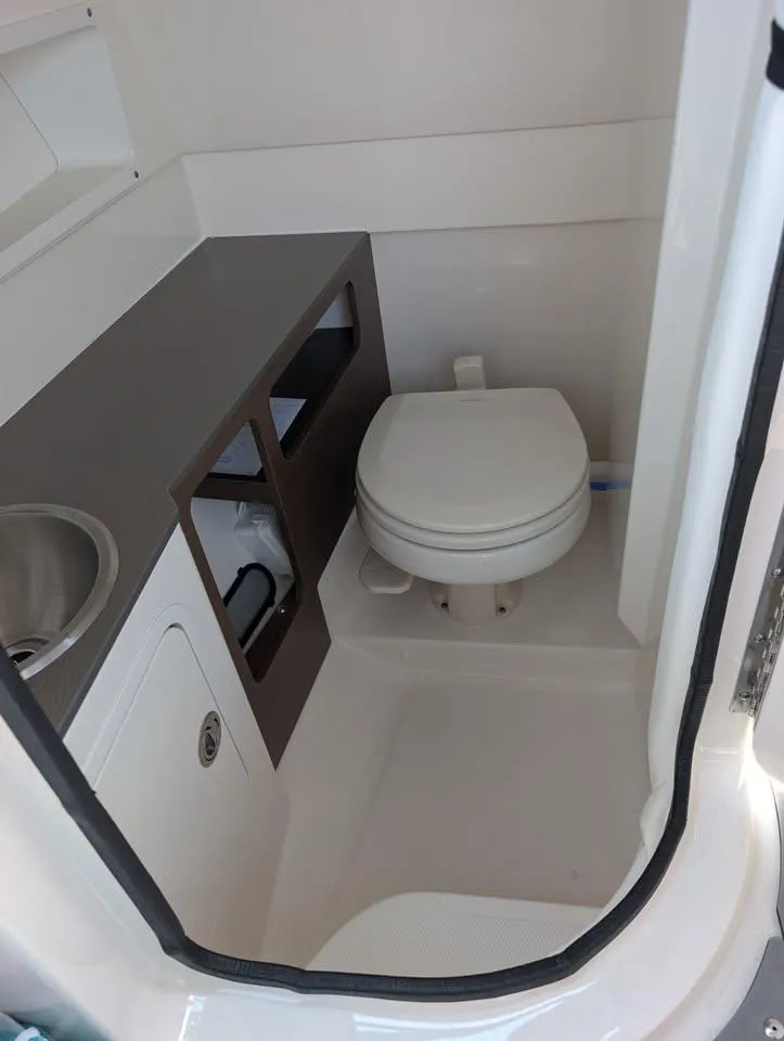 Slide: The Image of 2021 Sea Ray SDX 270 Outboard boat bathroom interior with toilet and sink. - 30