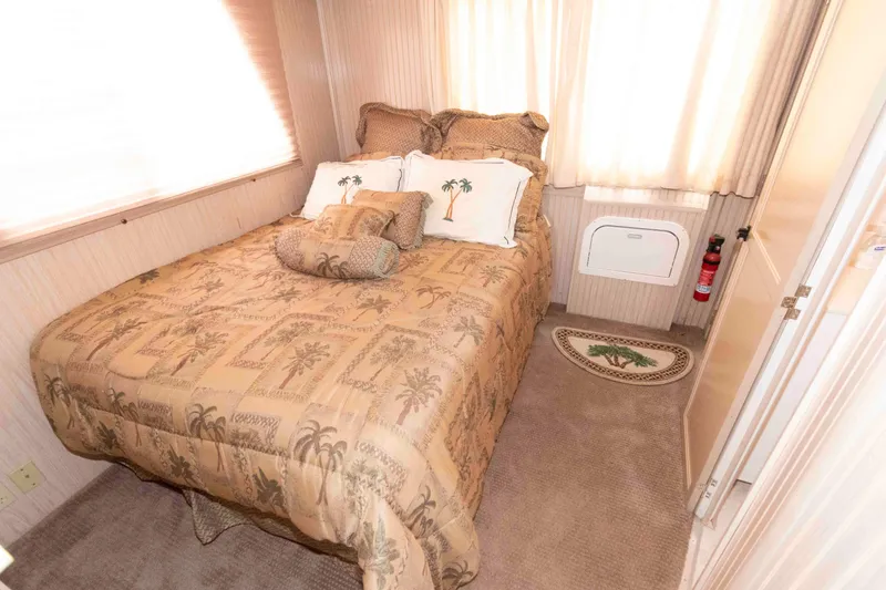 Slide: The Image of Cozy bedroom in 2004 Gibson 47 Classic with palm-themed decor and natural light. - 15