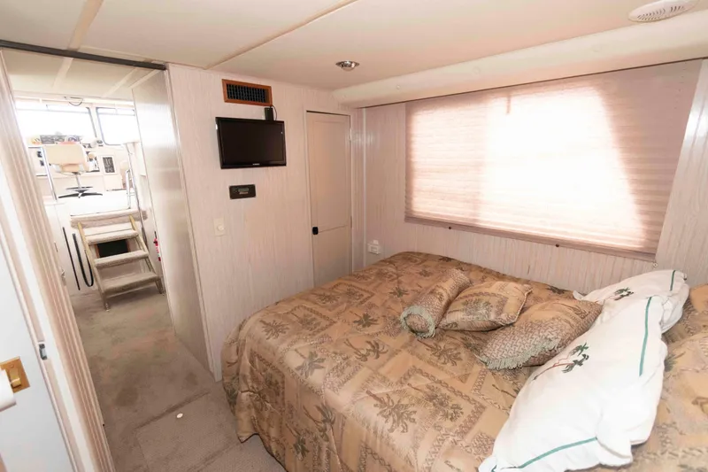 Slide: The Image of Cozy bedroom in 2004 Gibson 47 Classic boat with TV and patterned bedding. - 16