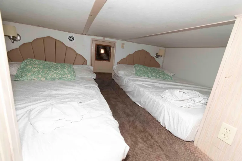 Slide: The Image of Interior of 2004 Gibson 47 Classic with twin beds and floral pillows. - 18