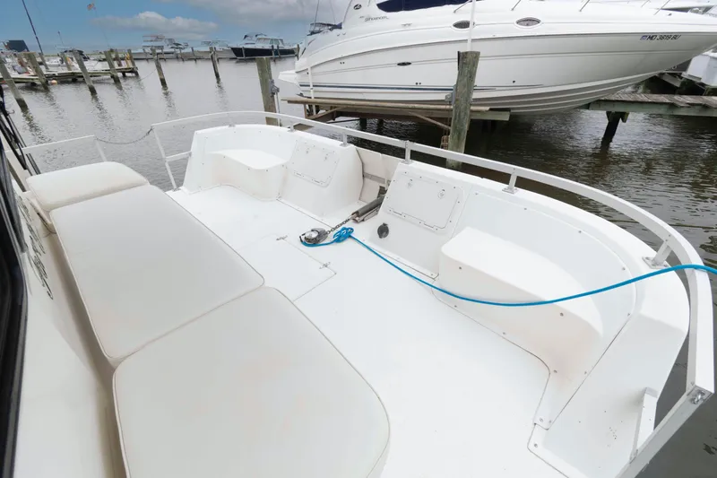 Slide: The Image of 2004 Gibson 47 Classic boat deck with seating, docked at marina. - 2