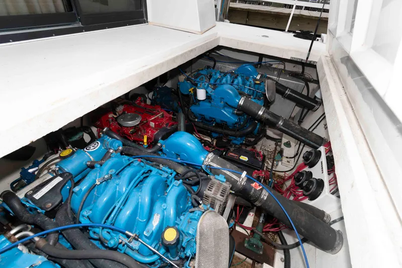 Slide: The Image of Engine room of a 2004 Gibson 47 Classic boat with blue and red engines. - 21