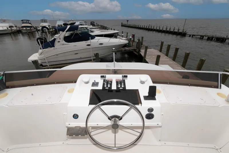 Slide: The Image of Helm of 2004 Gibson 47 Classic yacht docked at marina with boats and pier. - 6