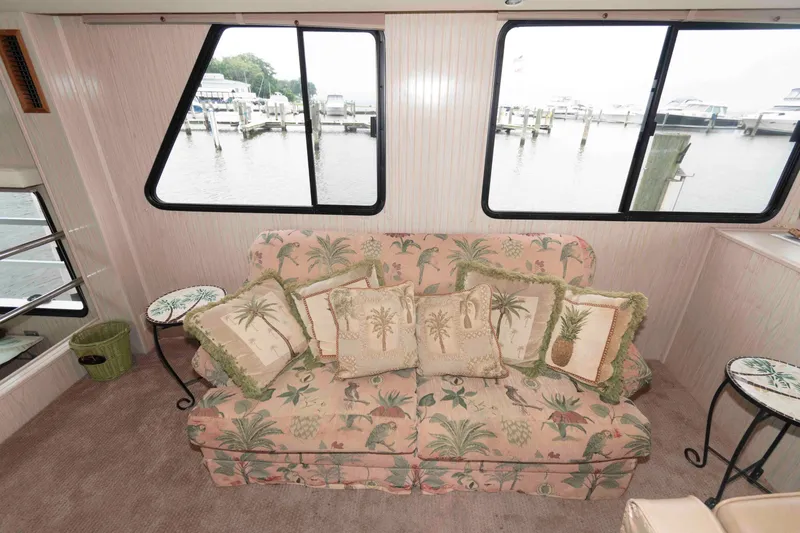Slide: The Image of Cozy boat interior with tropical-themed sofa, pillows, and marina view through large windows. - 8