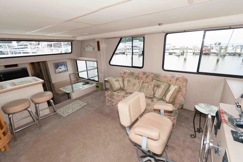Slide: The Image of Interior of 2004 Gibson 47 Classic boat with cozy seating and large windows. - 9