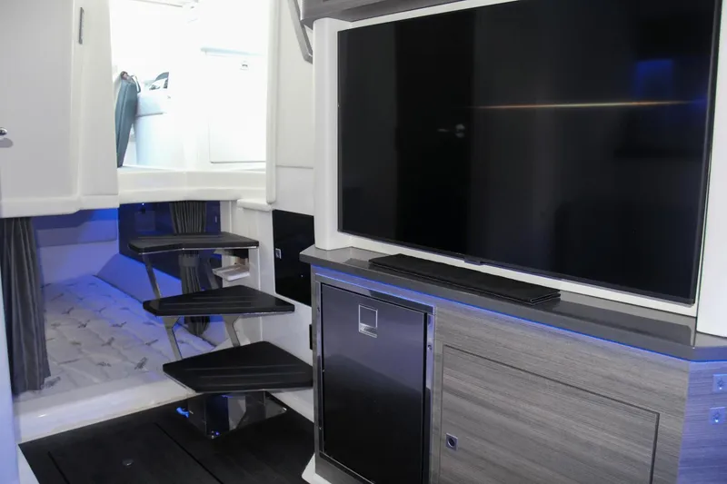 Slide: The Image of 2023 Aviara AV40 OB interior with TV, modern cabinetry, and sleek staircase. - 12