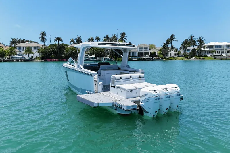 Slide: The Image of 2023 Aviara AV40 OB boat with triple outboard engines on a serene waterfront. - 7