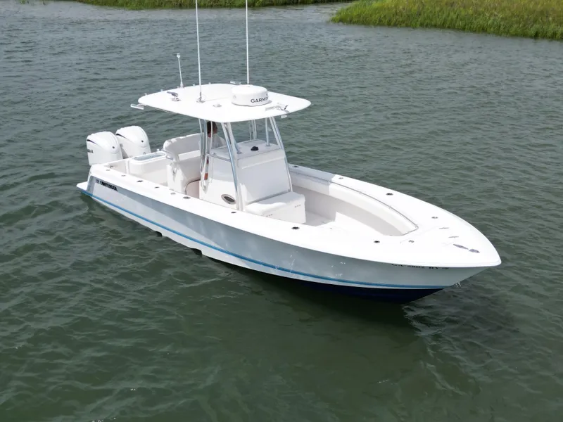 The Image of 2022 Contender 30 ST boat on calm water with grassy shoreline. - 0