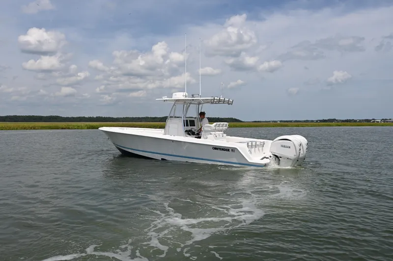 Slide: The Image of 2022 Contender 30 ST boat cruising on calm water under a partly cloudy sky. - 5