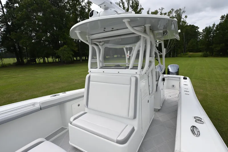 Slide: The Image of 2017 Yellowfin 36 boat with white seating and console, set on grassy background. - 10
